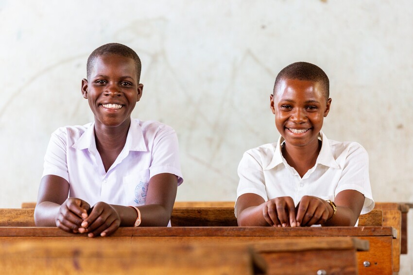 Schoolgirls smiling in a classroom at school in Geita region  