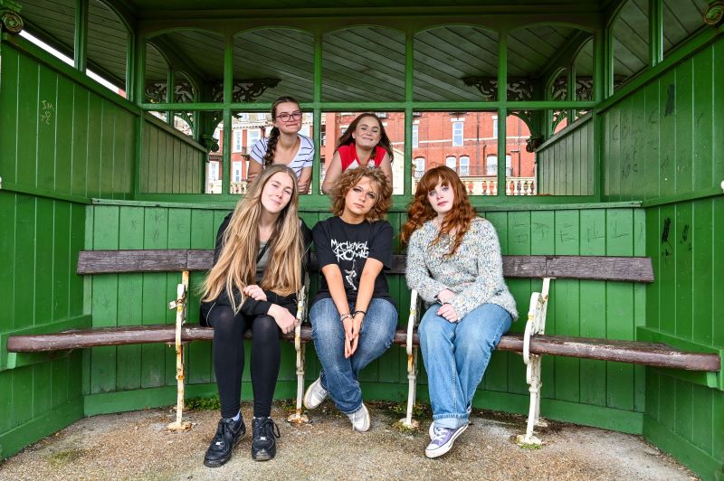 five girls smile at the camera