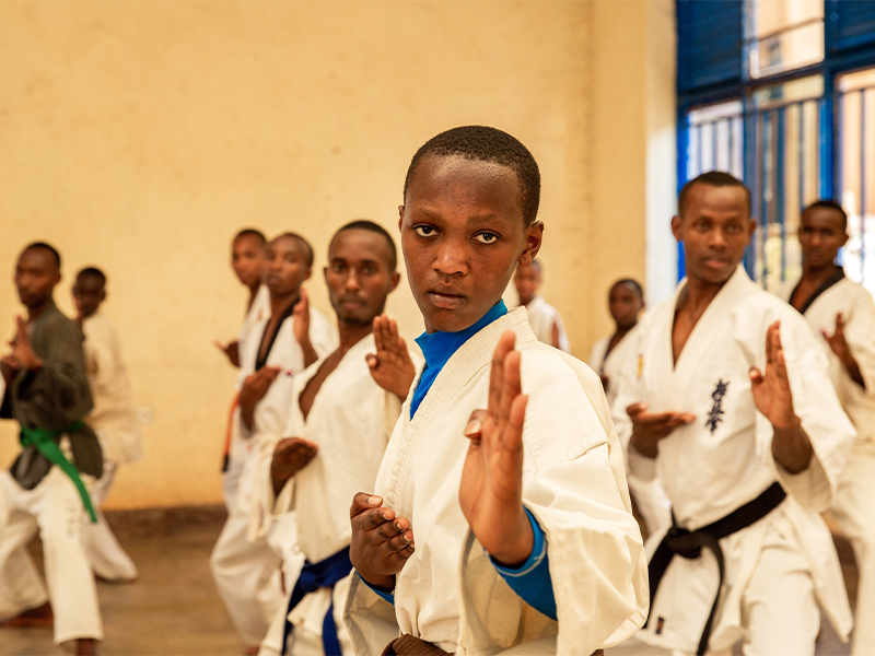 Group of people practising karate with Alliance at forefront