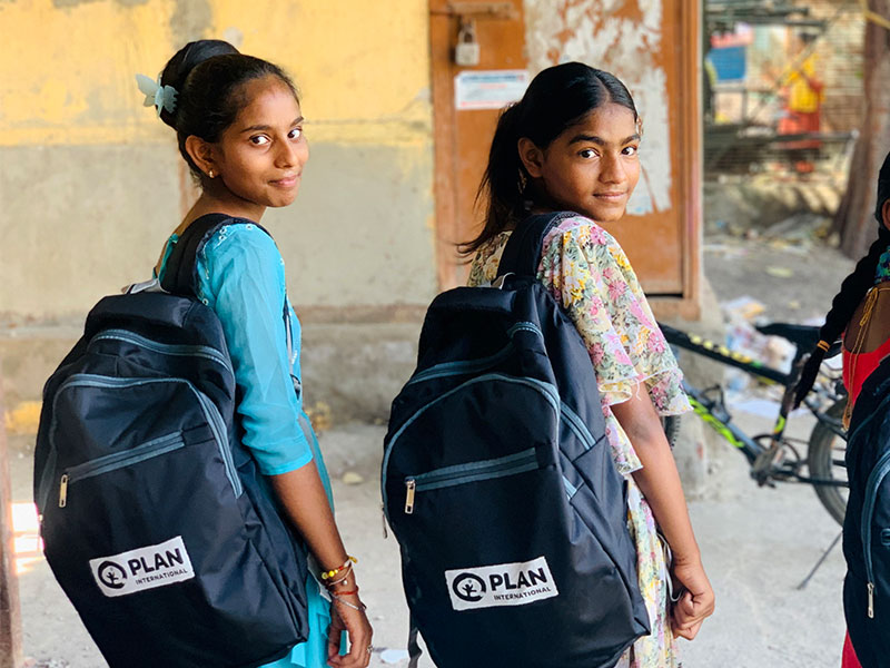 Girls with their new education kits from Plan International.