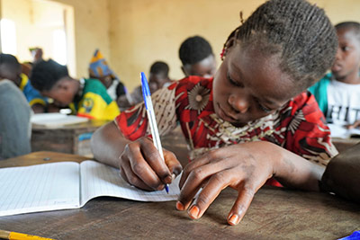 A school girl writing in her school book