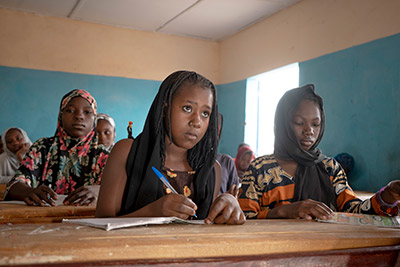 A school girl writing in her school book