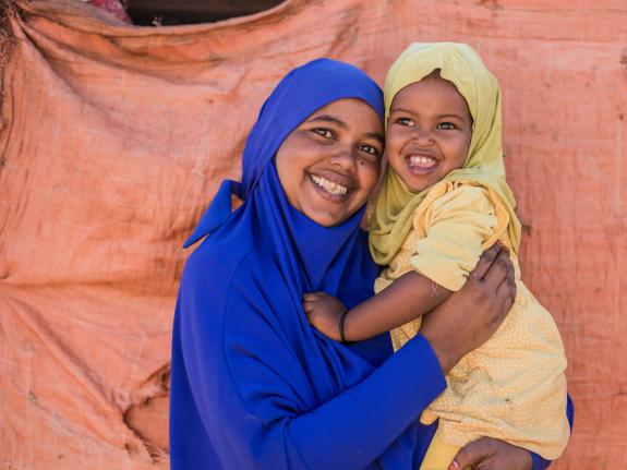 Cawon smiling and holding her daughter Misko