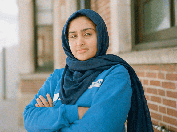 Maryam, member of Youth Advisory Panel, standing with arms crossed looking at camera