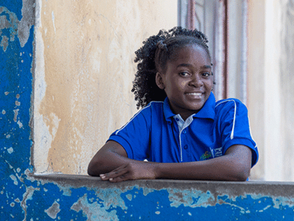 Eunice standing with arms crossed smiling at camera.