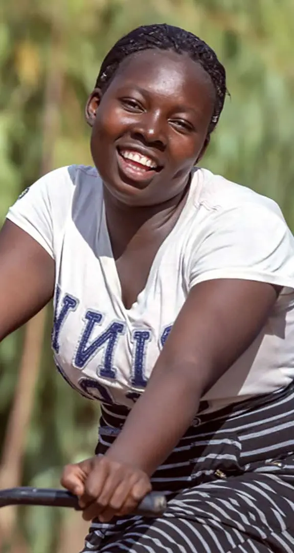 Two teenage girls in Malawi, riding a bicycle