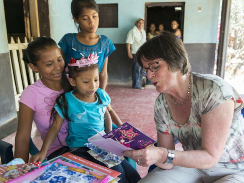 Coby Viergever reads 6th birthday card to the child she sponsors, Esteyedí. Photo credit: Marieke Viergever