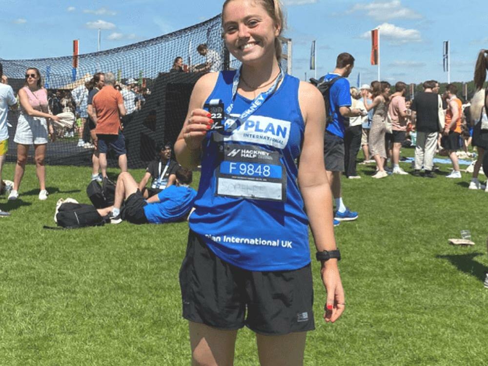 A female marathon runner holding up her medal