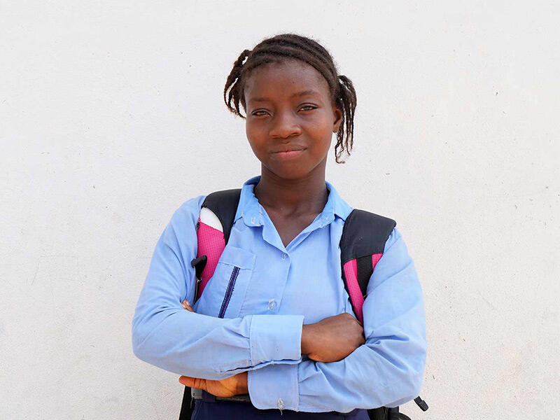 Princess standing with her arms crossed smiling at the camera