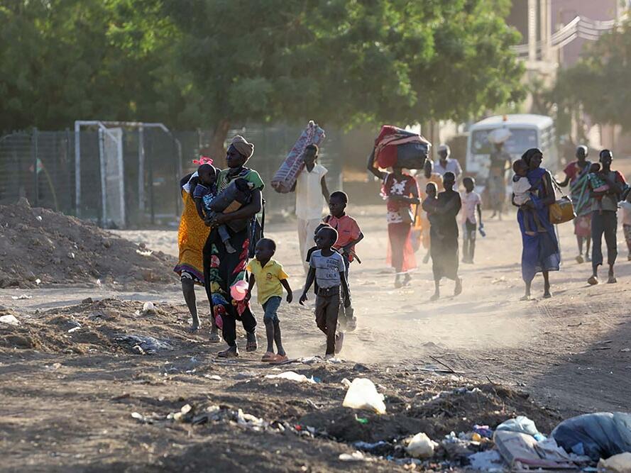 People flee their neighbourhoods amid fighting between the army and paramilitaries in Khartoum on April 19, 2023, following the collapse of a 24-hour truce.