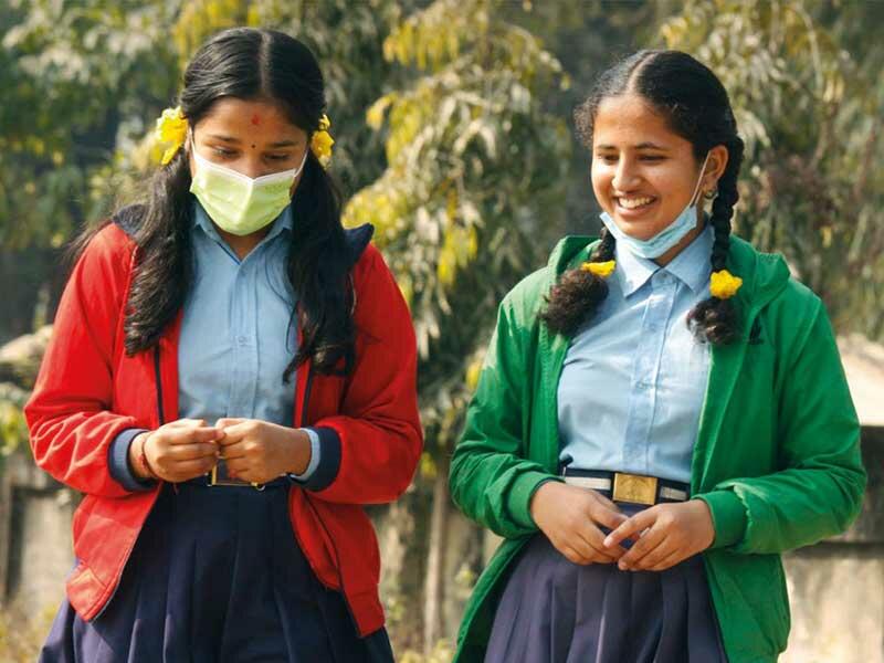 Two girls wearing blue face masks