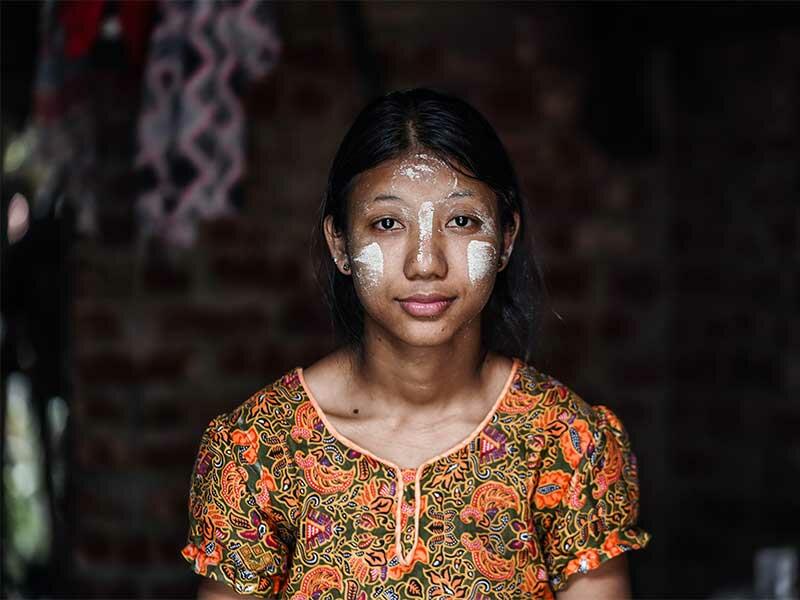 Useaking looking at camera with white decorative paint on cheeks and forehead