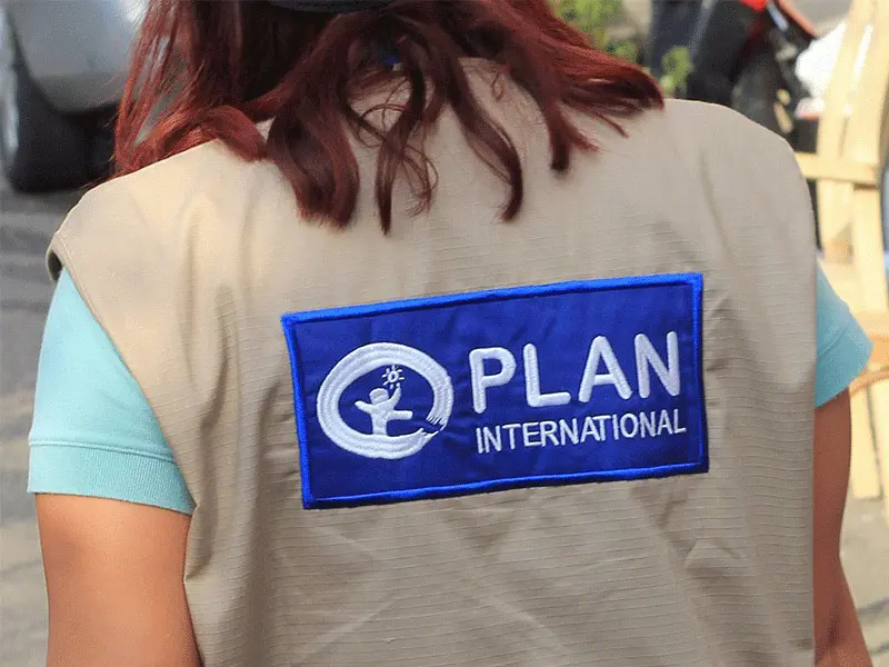 Back of a Plan International response team member's jacket with Plan International logo visible